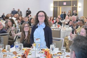 Standing: Alexandra Birenbaum, Reservation Coordinator, Meyer Jabara Hotels/Cambria Hotels White Plains Downtown, supported by The Arc Westchester; seated, holding phone up: Danielle Jabara, Senior Sales Manager, Meyer Jabara Hotels