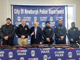 Assemblymember Jonathan Jacobson with Newburgh Police Chief Brandon Rola (left) and officers who helped run the event, standing with the firearms collected.