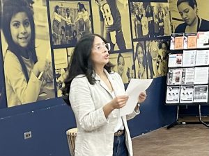 Laura Garcia a community volunteer reads a poem about one of the Kwanza Principles, the power of Collective Work.