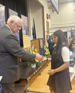 Diyani Garcia receives her diploma from Fqther Mark.