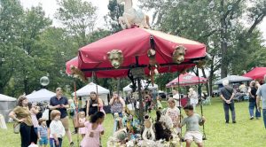 Children ride a hand-crafted, energy efficient merry-go- round at no cost during Sunday’s Corn Festival.