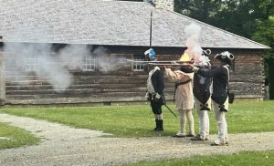 Members of the 1st Rhode Island Regiment perform military drills, including musket firings, for an attentive audience Saturday afternoon.