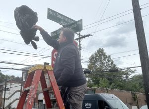 Superintendent of Public Works Chad Wade unveils the sign Rev. Saul Williams Way during street renaming ceremony to honor the legacy of Baptist Temple Church's founding pastor, Rev. Dr. Saul S. Williams.